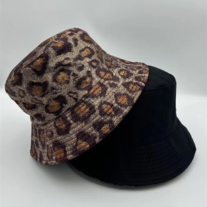 Detail view of leopard print and solid black bucket hats featuring high-quality fabric texture