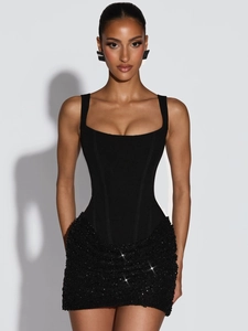Detail of a black bodycon dress with sequined skirt and spaghetti straps in studio lighting