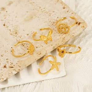 5-piece set of 18K gold-plated adjustable bow and starfish rings on a stone surface