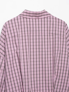 Gros plan du col et des coutures d'épaule d'une chemise à carreaux rose