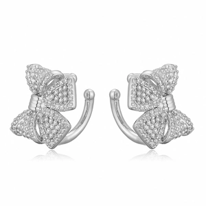 Detailed view of silver bow-shaped ear cuffs with sparkling transparent crystals