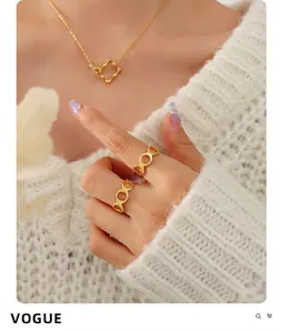 Detailed close-up of a 18K gold plated hollow 8-shape ring worn on a white knit sweater