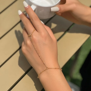 Close-up of a gold ring bracelet set with rhinestones and faux pearls on a wrist