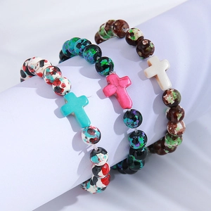 Detail of colorful speckled bead bracelets with turquoise pink and white cross pendants