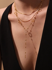Multi-layered gold necklace with tassel flower pendant and zircon beads on model