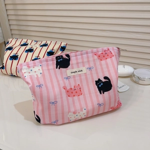 Détail des trousses à maquillage en coton à rayures roses avec motifs de chats mignons