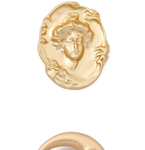Macro shot of gold baroque brooch with vintage portrait relief and matte metal texture
