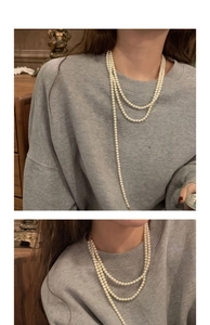 Detail showing multi-layer vintage pearl necklace with elegant round white pearls