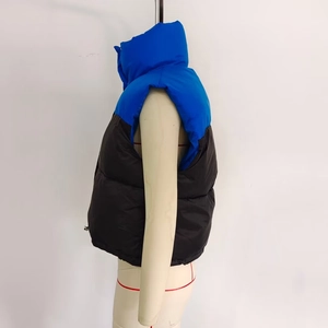 Détail du gilet matelassé bicolore bleu et noir avec col montant et fermeture éclair