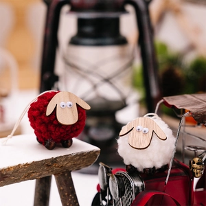 Detail of red and white handmade wool felt sheep ornaments with wooden heads on a festive table