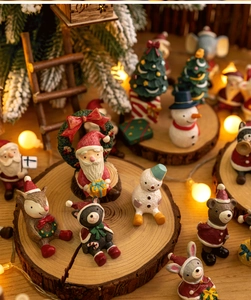 Macro detail of miniature Christmas resin figurines displayed on a rustic wood base