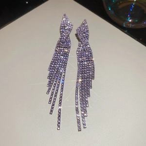 Macro shot of silver tassel earrings with sparkling rhinestones and long fringe detail