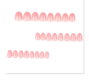 Detailed flat lay of pink press-on nails with white daisy flowers and striped patterns