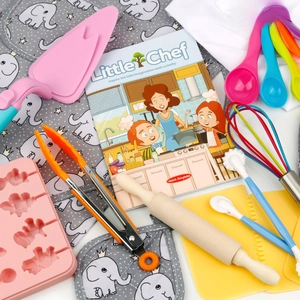 Detailed kids baking set with dinosaur molds, wooden rolling pin, and chef cookbook