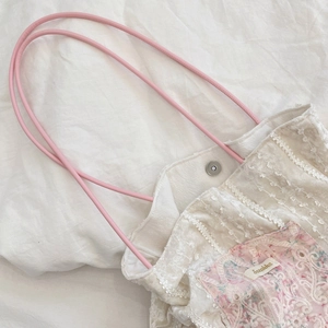 Détail du sac cabas en toile fleurie avec bordure en dentelle et fermoir magnétique
