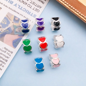 Macro view of colorful enamel heart charms in eight bright colors for DIY jewelry making