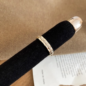 Détail de la bague dorée texturée avec ligne centrale en micro-zirconiums incrustés