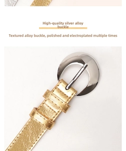 Detail of silver alloy buckle and golden textured leather belt for women jeans