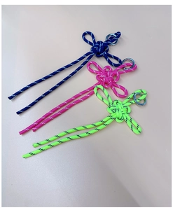 Detailed view of handmade woven clover knot charms in blue, pink, and neon green colors