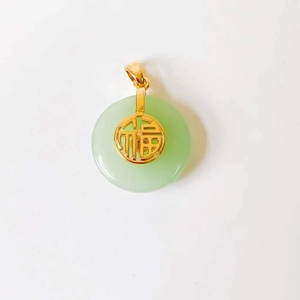 Detail view of round green jade pendant with gold Fu character and lobster clasp