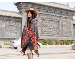 Detailed view of the ethnic geometric patterns and long tassels on the thick cashmere shawl