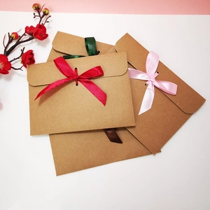 Flat lay of vintage kraft paper envelopes with colorful silk ribbons for gift packaging