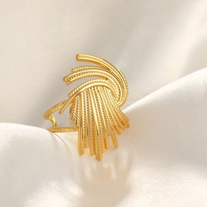 Macro shot of gold-plated hammered texture layered ring on white silk fabric folds