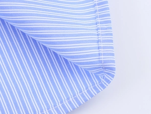 Macro del tessuto di cotone a righe blu e bianche con dettagli di cuciture curate