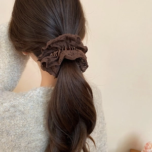 Detail view of coffee brown lace scrunchie with hollow embroidery on a ponytail
