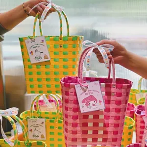 Handwoven bucket bag in colorful checkered pattern with festive ribbon and gift card