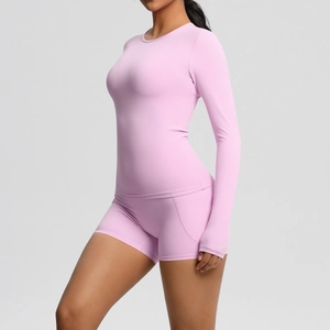 Détail du tissu brossé rose-violet doux sur le haut de yoga à manches longues et short