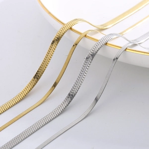 Close-up of gold and silver layered herringbone snake chains in multiple widths