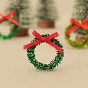 Miniature Christmas wreath decoration with green tinsel and a red silk ribbon bow