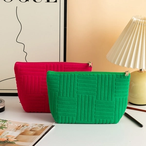 Detail of green and rose red cosmetic bags with textured stripe pattern and gold zipper
