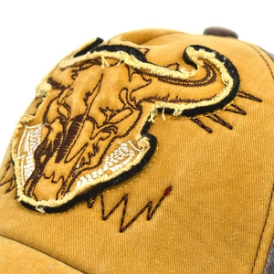 Detail of vintage washed cotton baseball cap with cow skull patch and distressed edges