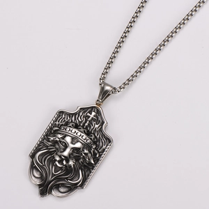 Détail du pendentif roi lion en forme de bouclier avec gravures de couronne et croix