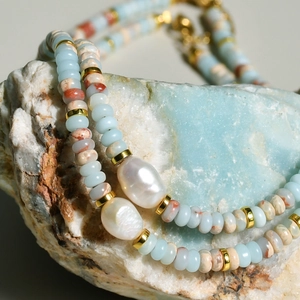 Detail of freshwater baroque pearls and blue natural stones on a light blue mineral rock