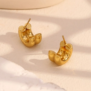 Détail macro de boucles d'oreilles créoles C double couche plaquées or 18 carats avec poli