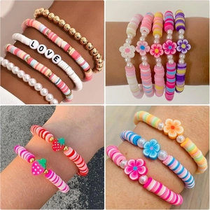 Gros plan de bracelets en perles Heishi colorées avec breloques lettres Love et fleurs