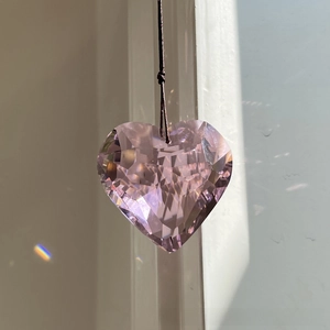 Macro detail of 45mm light purple heart crystal prism with faceted rainbow light refraction
