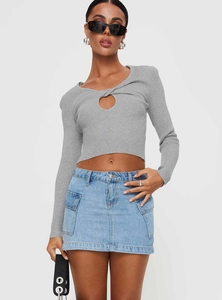 Gros plan d'une mini-jupe cargo en denim bleu clair avec un haut en maille grise