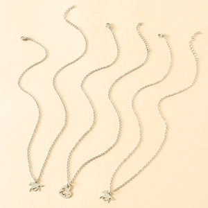 Detail showing silver horse pendant necklaces with adjustable lobster clasp on beige fabric