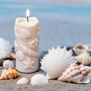 Detailed relief of sea shells and starfish on a white cylindrical scented candle