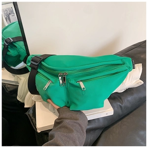 Detail of green nylon crossbody bag with adjustable wide strap and silver metal zippers