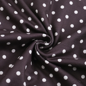 Gros plan d'un tissu à pois élégant montrant une texture lisse et un drapé en spirale