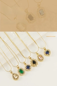 Detail view of gold-plated necklaces with emerald, ruby, and sapphire zircon pendants