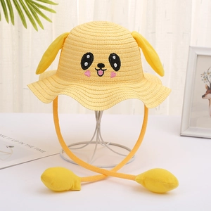 Detail of yellow straw sun hat with movable dog ears and cartoon embroidery for kids