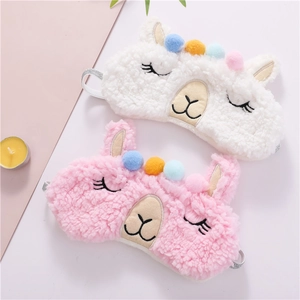 Close-up of plush alpaca sleep masks with colorful pom-poms and soft faux fur texture