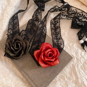 Detail of lace choker with 3D roses and pearl pendant on a textured background