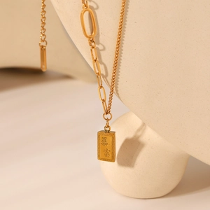 18K gold plated stainless steel necklace featuring a rectangular prosperity pendant on a geometric stand